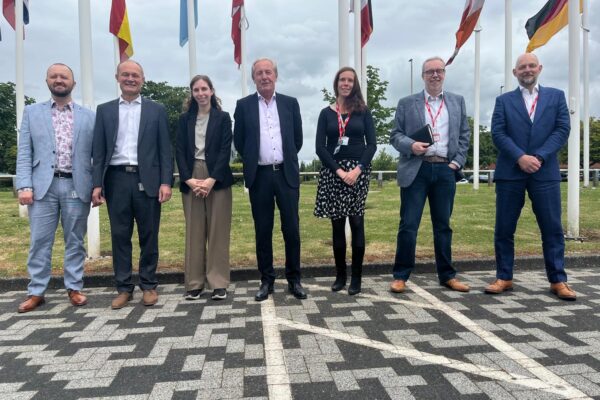 Digital Infrastructure and England’s Connected Heartland team with European Space Agency (ESA) team members standing outside of the building next to the flags