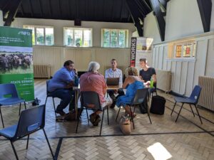 a group of local farmers sitting at a table discussing how 5G may support their business