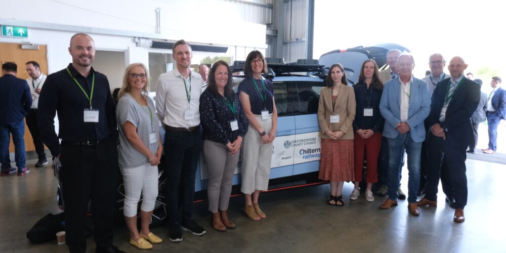 Members of the ECH team stand on the left and right of the parked EV used on the testing day.